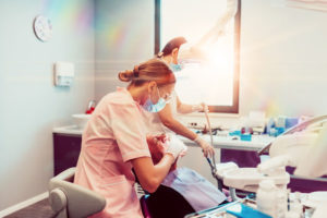 two nurses placing dental implants for a dental patient.